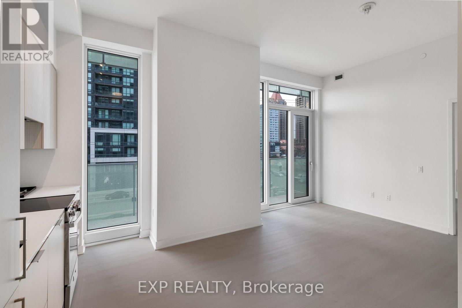 A white interior space with a window overlooking a cityscape.