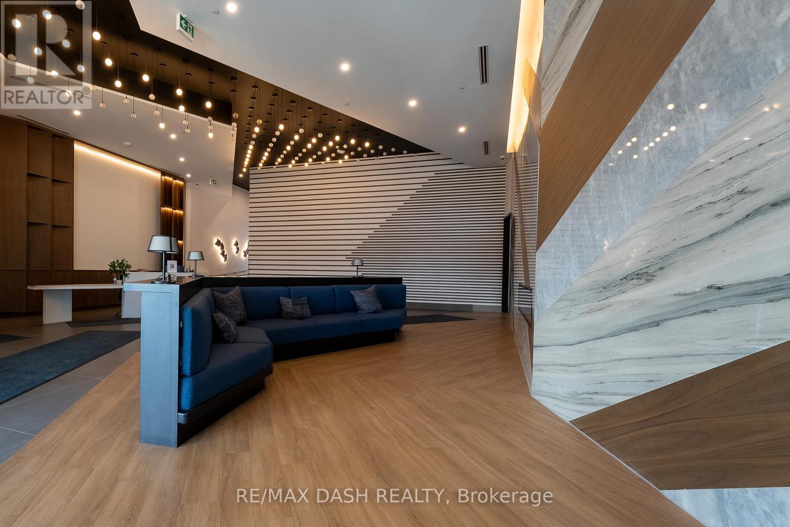 A modern office space with a blue sofa and wooden flooring.