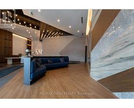 A modern office space with a blue sofa and wooden flooring.