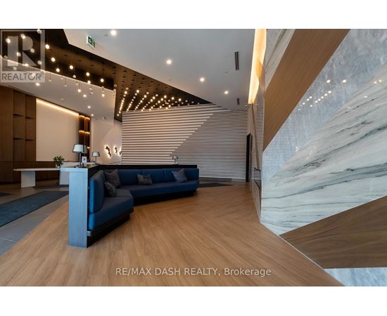 A modern office space with a blue sofa and wooden flooring.