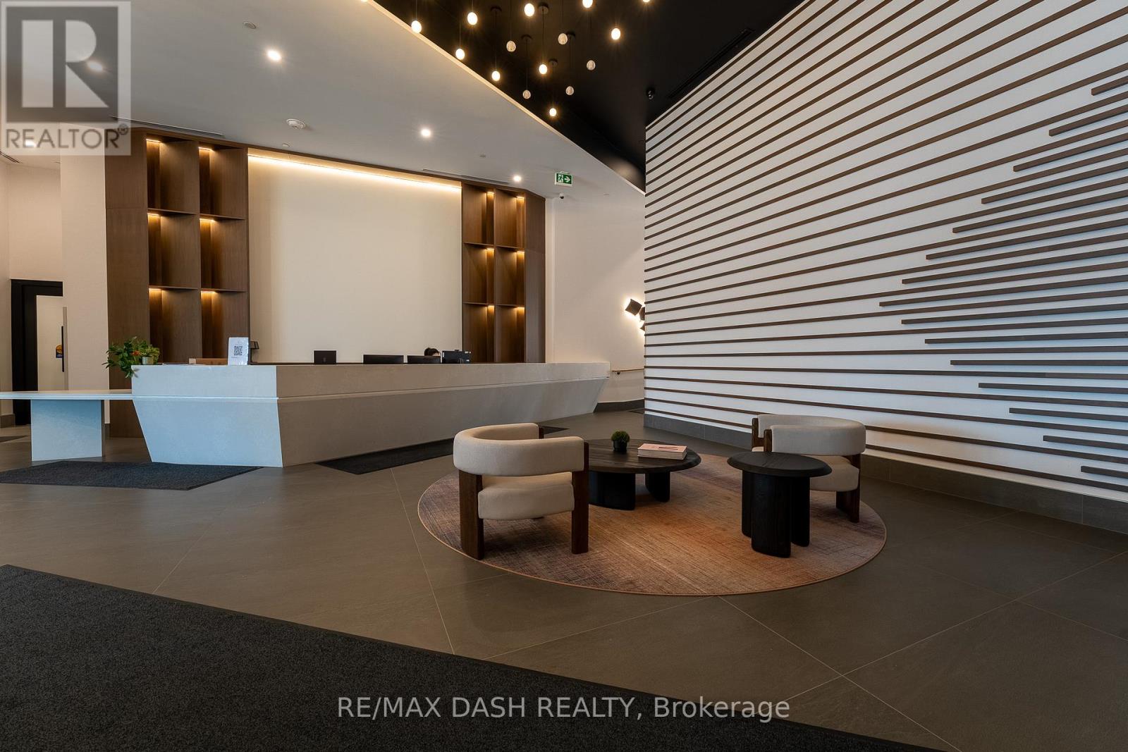 A modern office lobby with a reception desk and seating area.