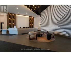 A modern office lobby with a reception desk and seating area.