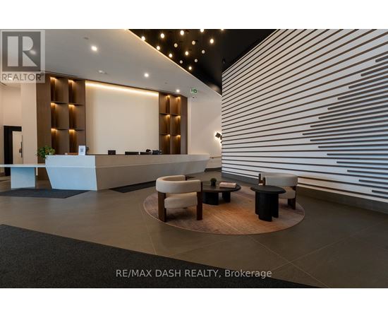A modern office lobby with a reception desk and seating area.
