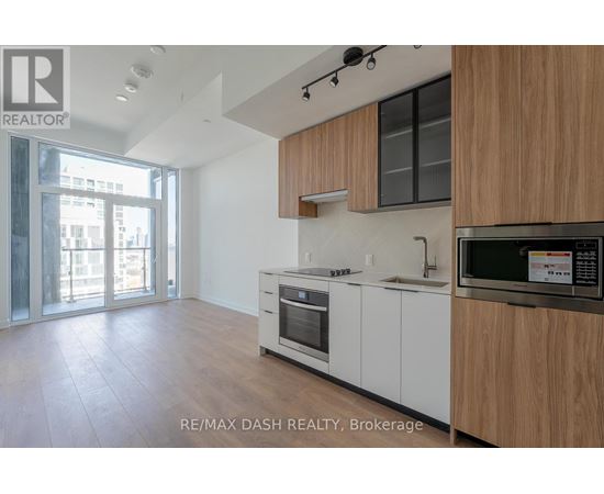 A modern kitchen with white cabinets and a wooden countertop.