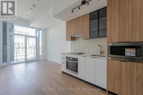 A modern kitchen with white cabinets and a wooden countertop.