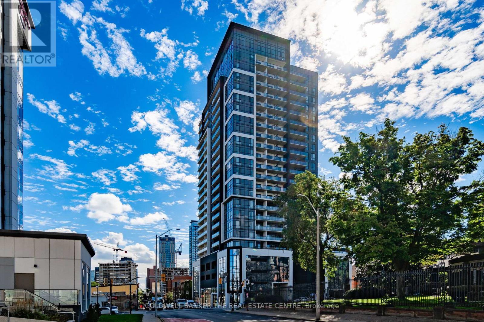 A tall building with many windows is the focal point of the image.