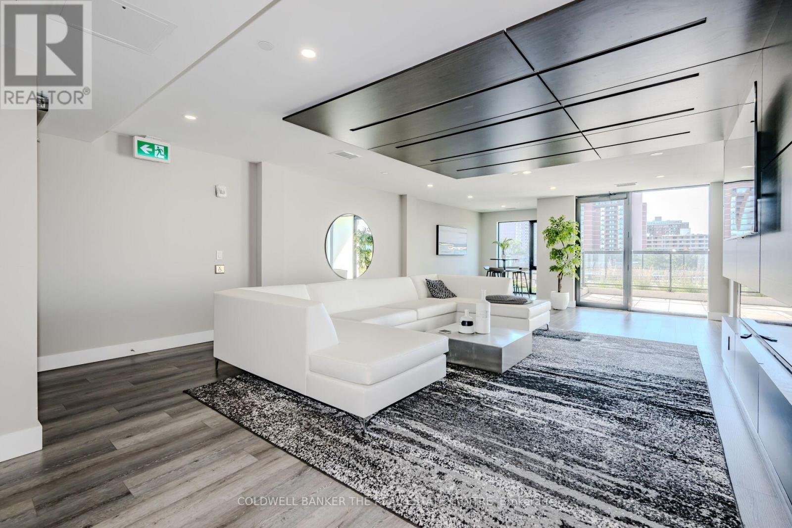 A modern living room with a white sofa and a black and white rug.
