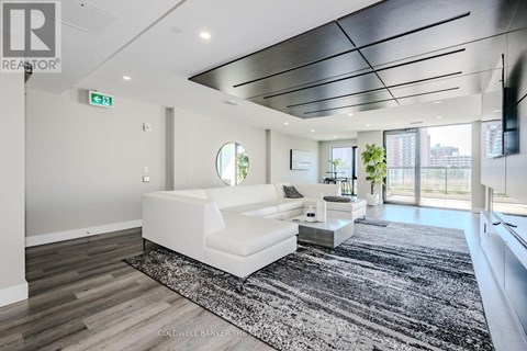 A modern living room with a white sofa and a black and white rug.