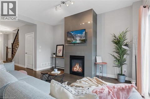 A living room with a fireplace and a television mounted on the wall.