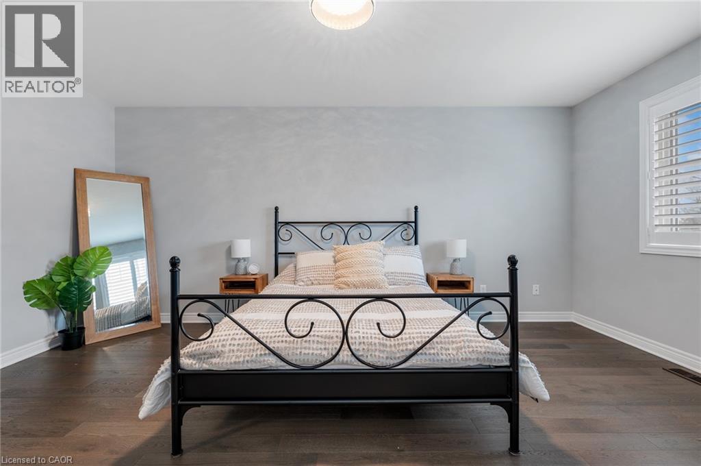A bedroom with a black metal bed frame and a mirror on the wall.