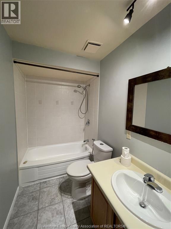 A white toilet is next to a bathtub in a bathroom.
