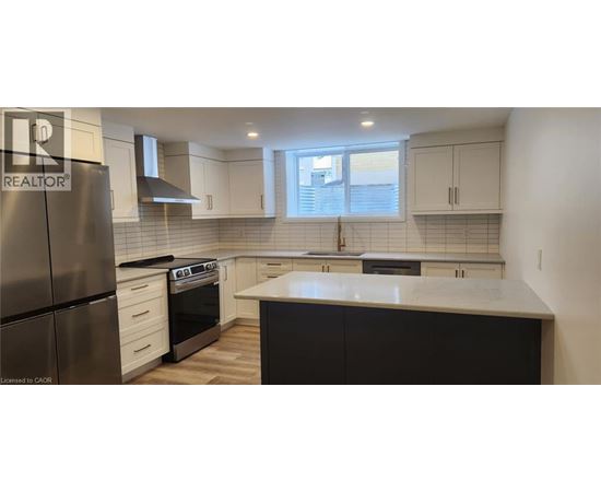 A kitchen with a refrigerator, stove, and oven.