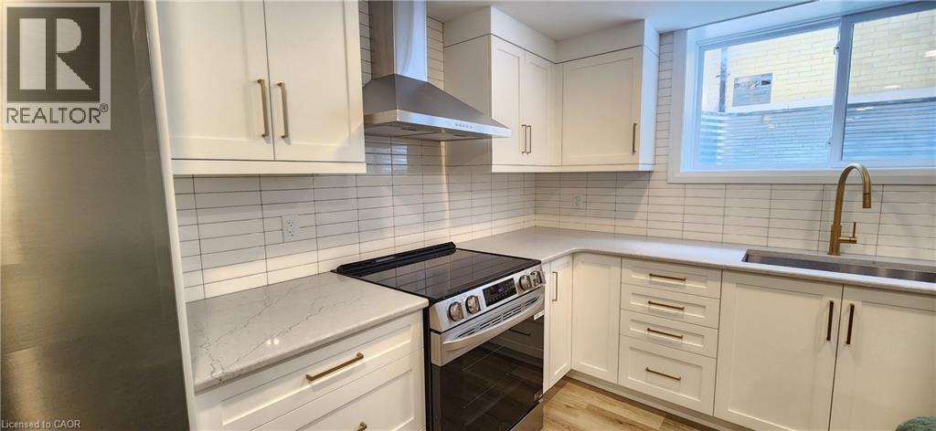 A kitchen with white cabinets and a black stove top.