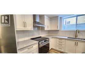 A kitchen with white cabinets and a black stove top.