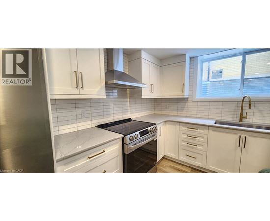 A kitchen with white cabinets and a black stove top.