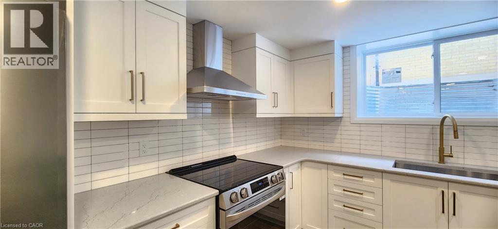 A kitchen with white cabinets and a black stove top oven.