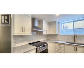 A kitchen with white cabinets and a black stove top oven.