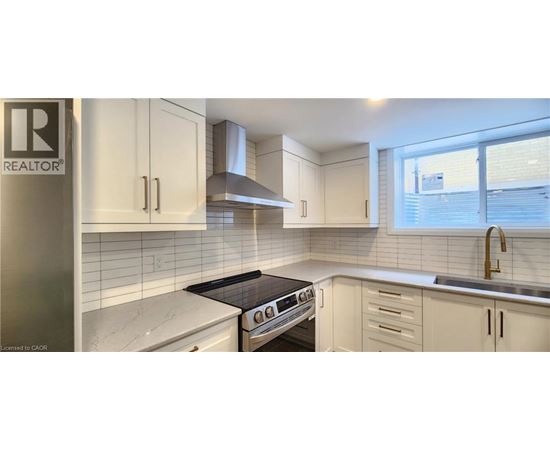 A kitchen with white cabinets and a black stove top oven.