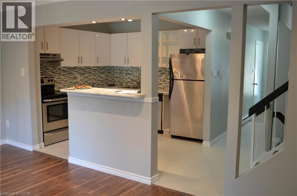 A kitchen with a refrigerator, oven, and cabinets.