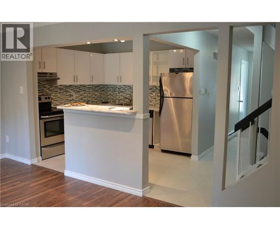 A kitchen with a refrigerator, oven, and cabinets.