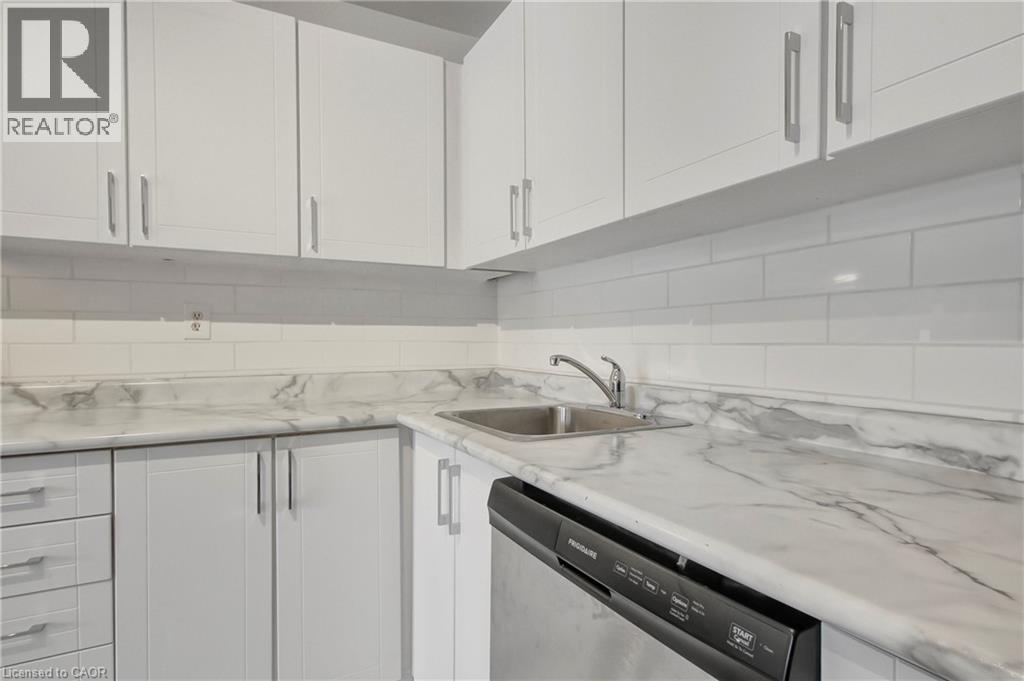 A modern kitchen with white cabinets and a marble countertop.