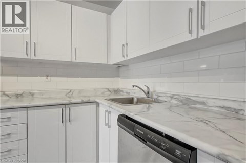 A modern kitchen with white cabinets and a marble countertop.