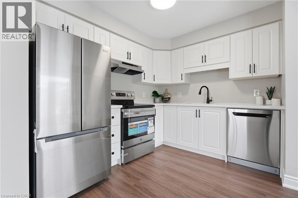 A modern kitchen with a stainless steel refrigerator and white cabinets.