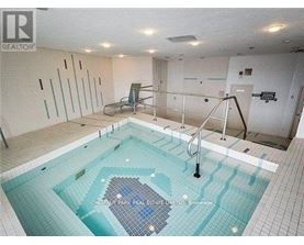 A swimming pool in a room with a tiled floor and walls.