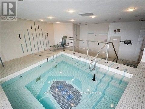 A swimming pool in a room with a tiled floor and walls.