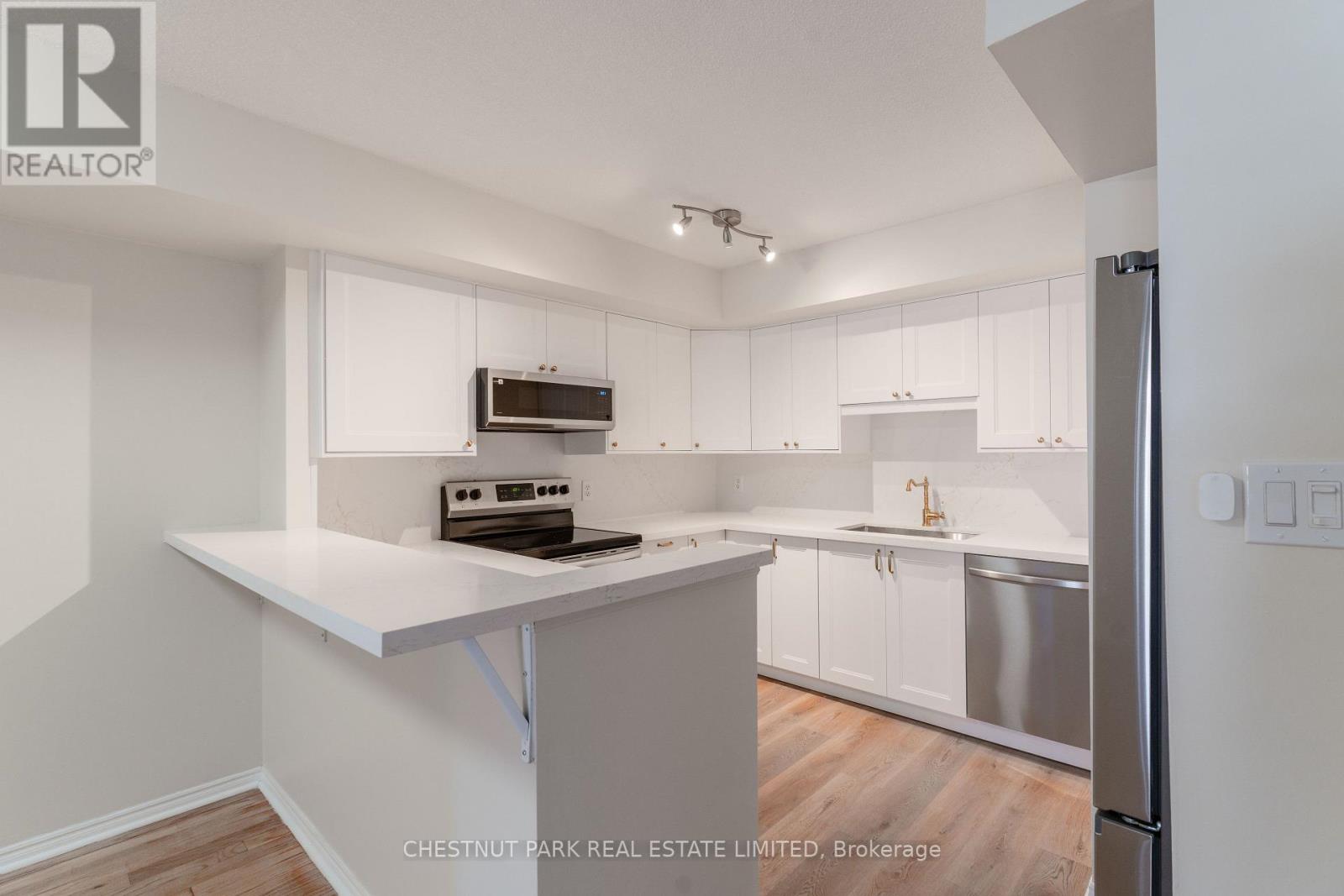 A kitchen with white cabinets and a white island.