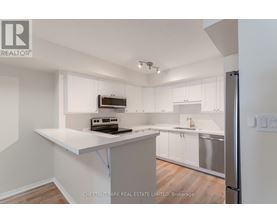 A kitchen with white cabinets and a white island.