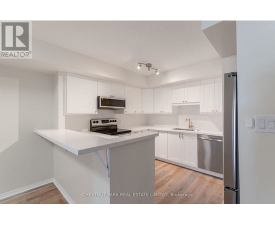 A kitchen with white cabinets and a white island.