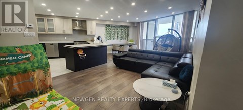 A living room with a black leather couch and a white coffee table.