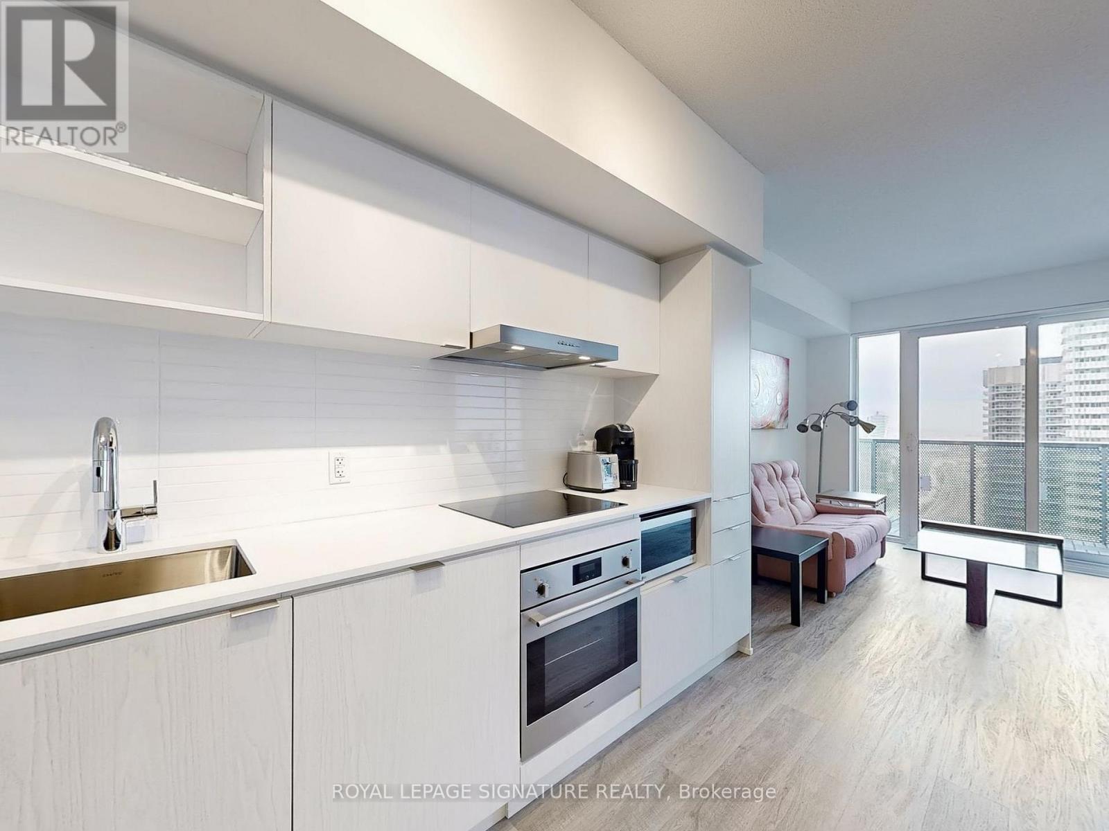 A modern kitchen with white cabinets and stainless steel appliances.