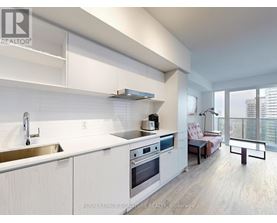 A modern kitchen with white cabinets and stainless steel appliances.