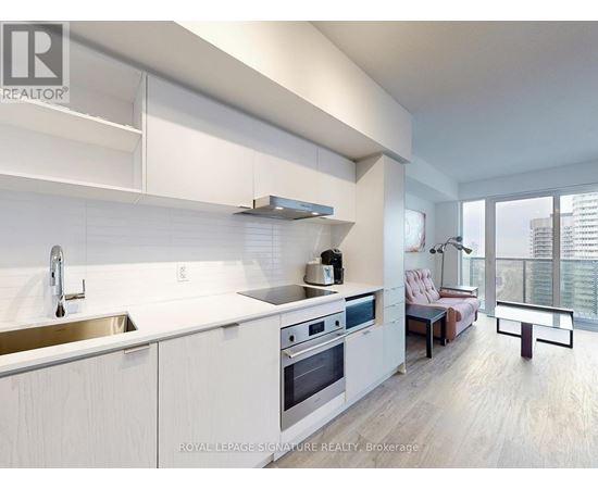 A modern kitchen with white cabinets and stainless steel appliances.
