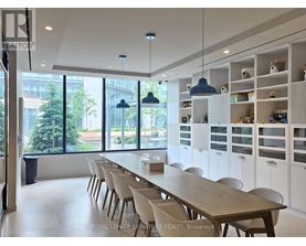 A dining room with a long table and chairs.