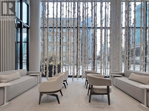 A living room with white furniture and a view of a city skyline through a window.