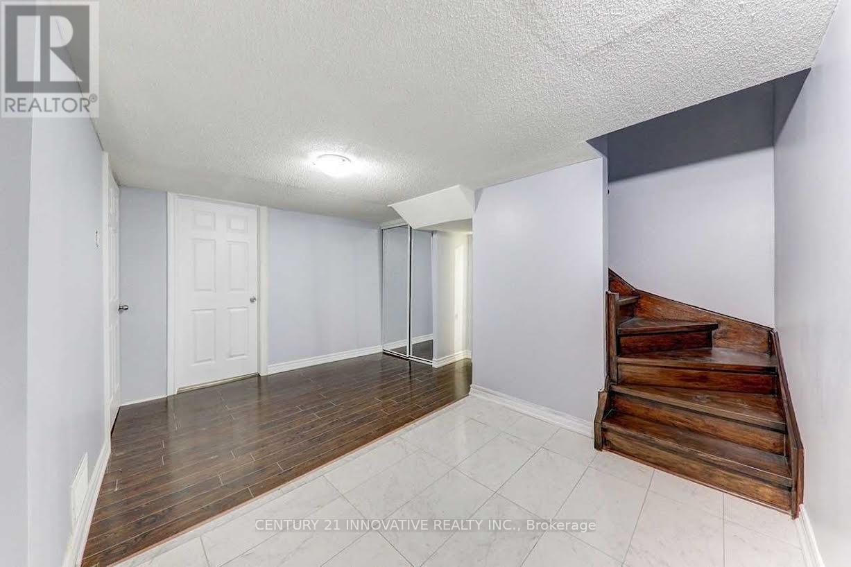 A room with a white ceiling, wooden floor, and a wooden bench.