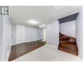 A room with a white ceiling, wooden floor, and a wooden bench.