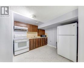 A kitchen with white appliances and wooden cabinets.