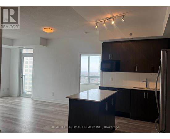 A kitchen with a black counter top and a refrigerator.