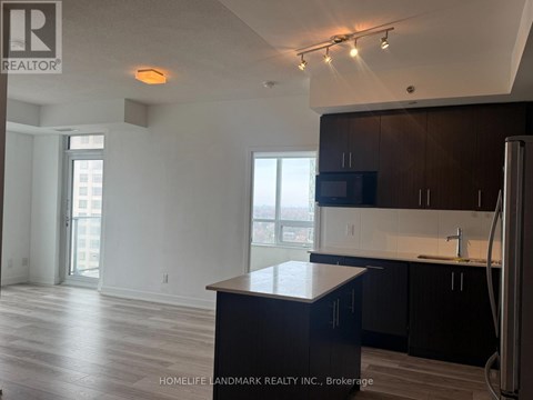 A kitchen with a black counter top and a refrigerator.