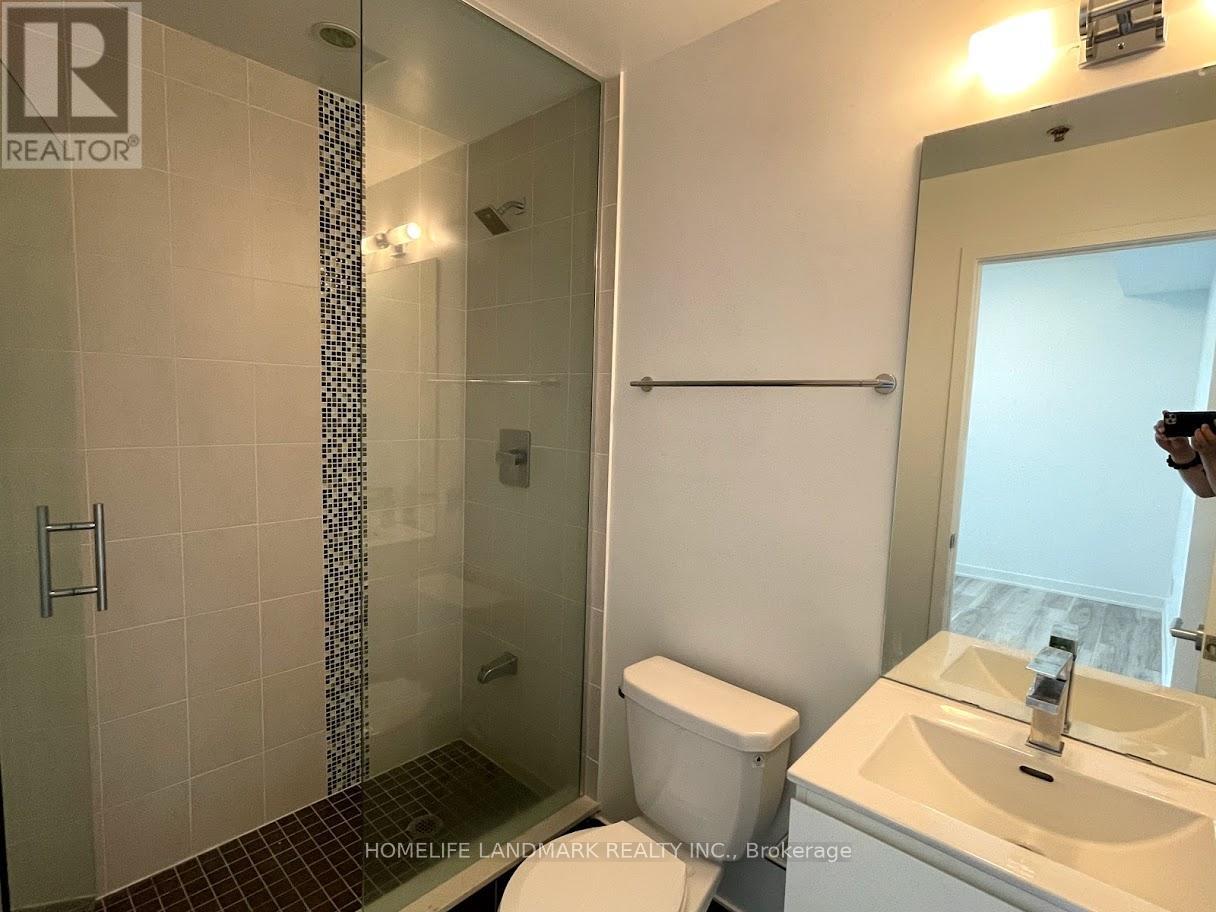 A bathroom with a toilet, sink, and shower.