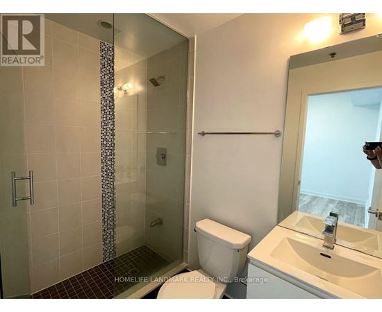 A bathroom with a toilet, sink, and shower.
