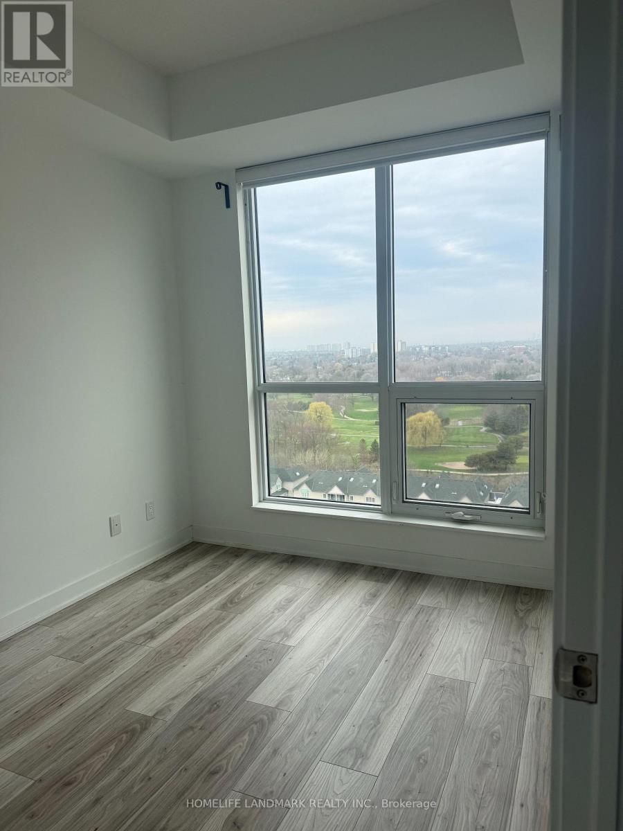 A room with a large window overlooking a green landscape.