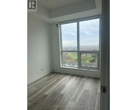 A room with a large window overlooking a green landscape.