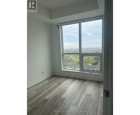 A room with a large window overlooking a green landscape.