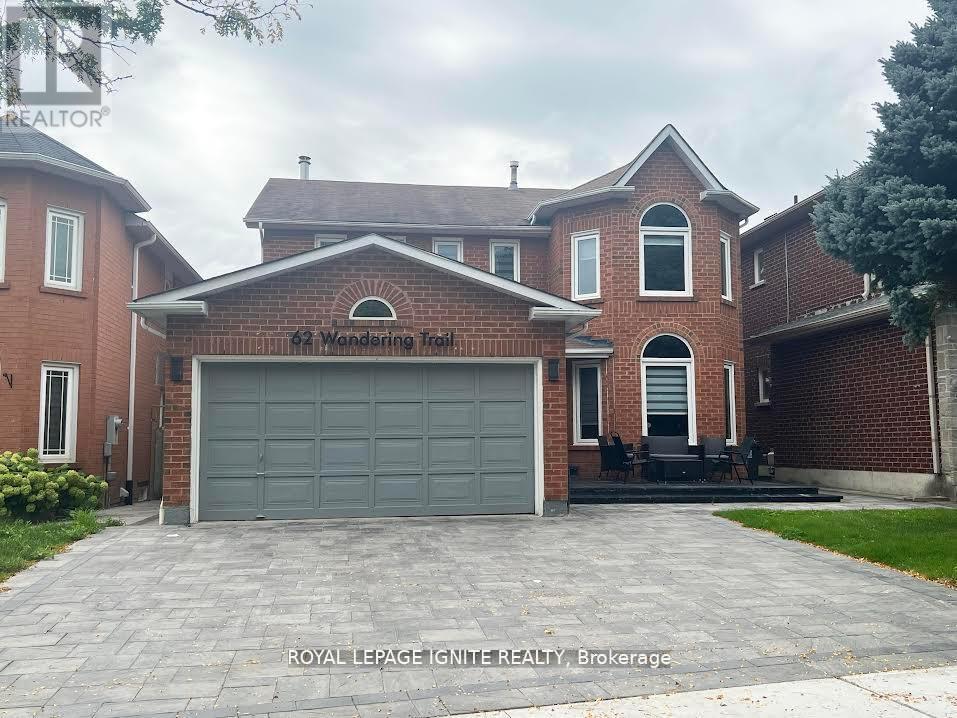 A house with a garage and a driveway in front of it.
