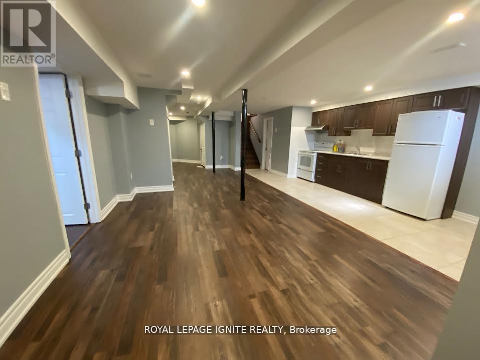 A spacious room with wooden flooring and white walls.